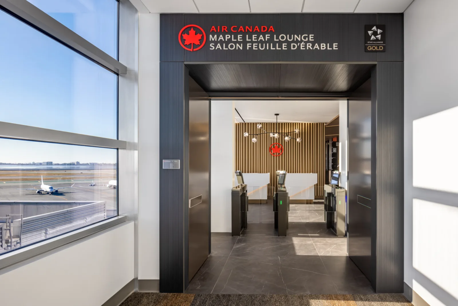 Maple Leaf Lounge entrance at San Francisco, Star Alliance Gold access signage beside the reception desk and entry turnstiles.