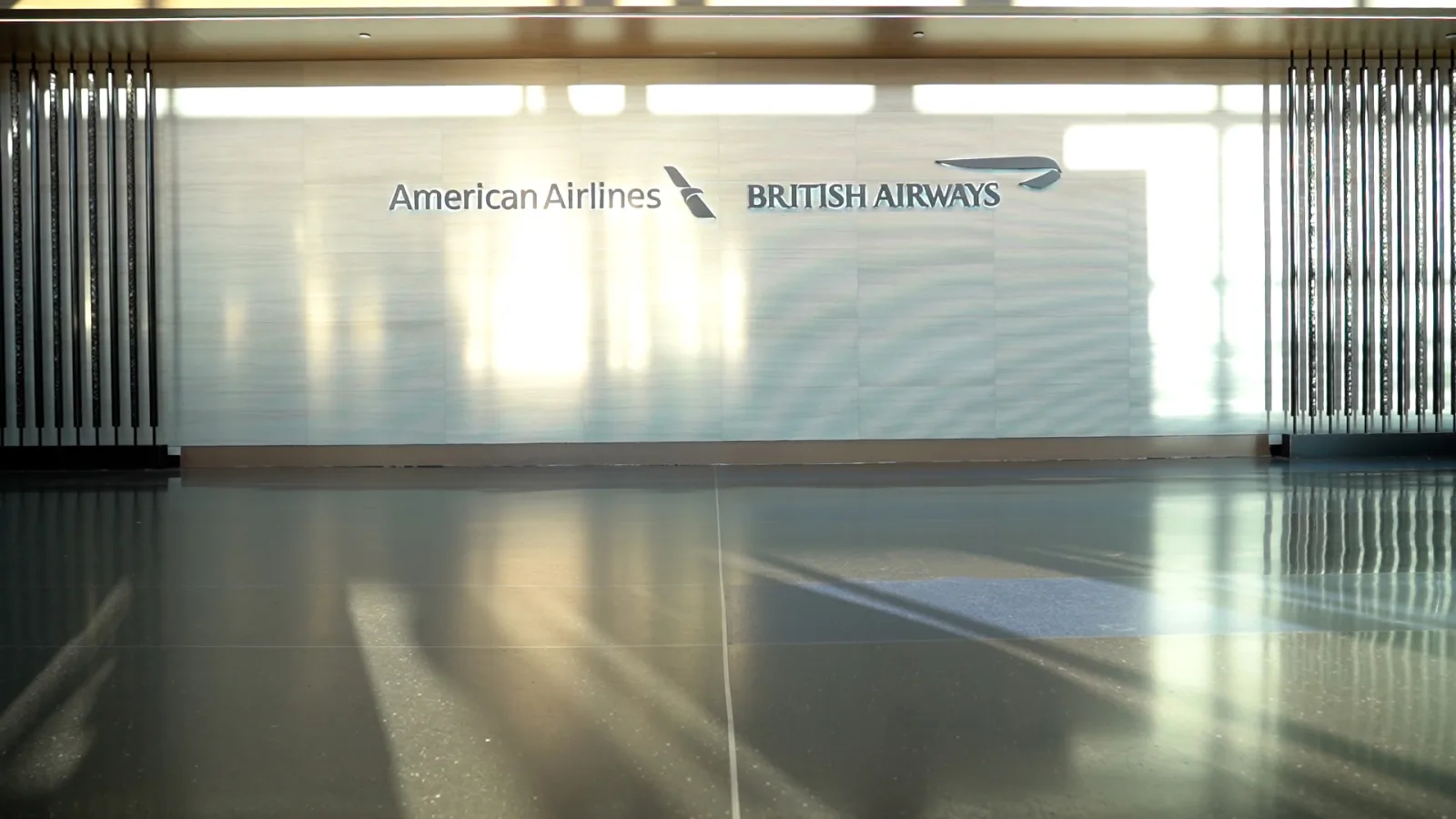 Co-branded British Airways and American Airlines premium check-in signage on a bright terminal wall.