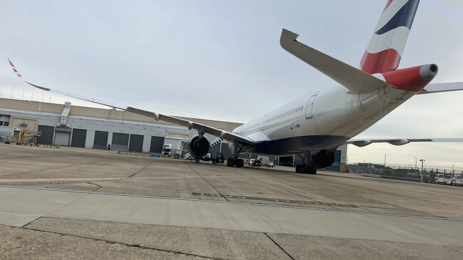 A British Airways Airbus A350-1000 parked at London Heathrow seen from behind the tail, Union flag tailfin above the apron