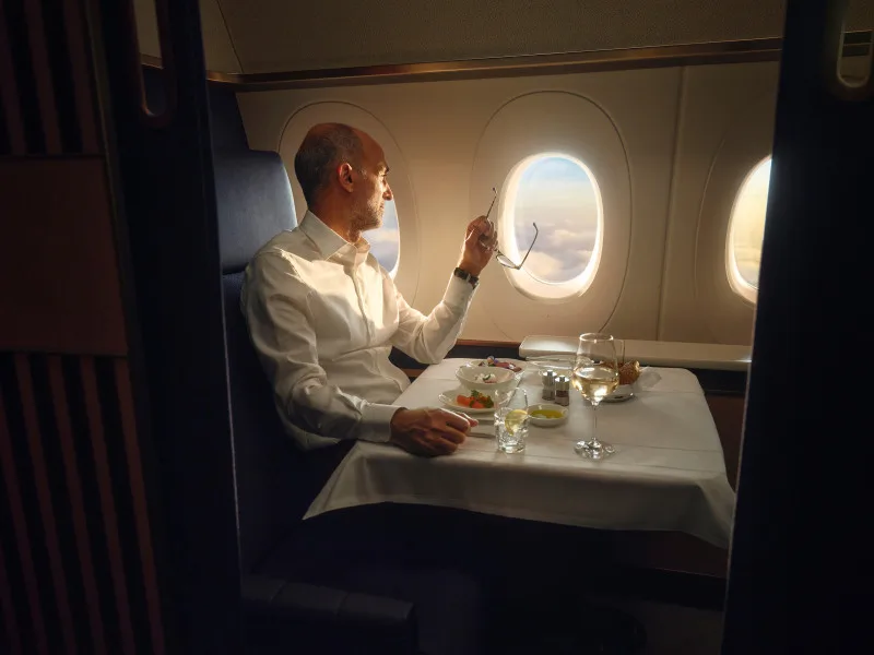 Lufthansa First Class dining service at a fully dressed table beside the window, a HON Circle and Senator redemption target.